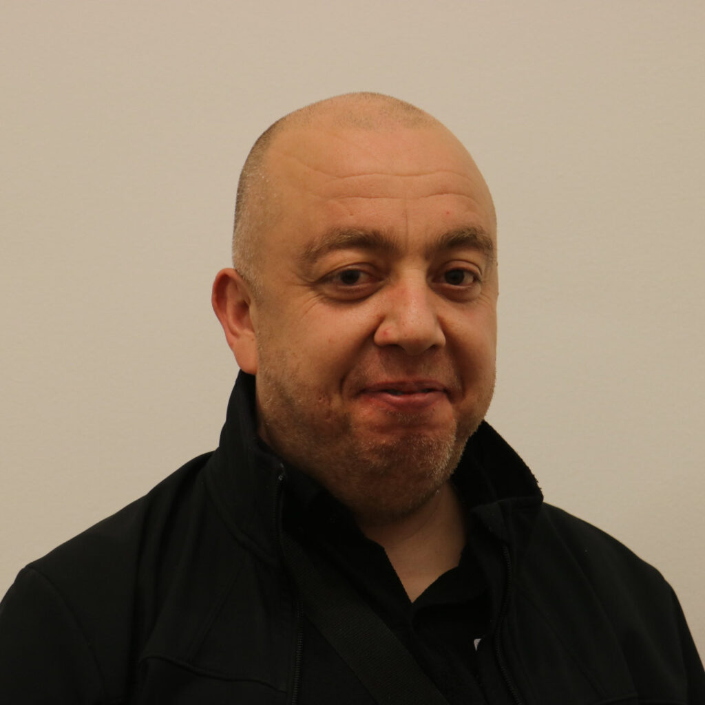 Profilbild von Hasan Can, mit Glatze und schwarzer Jacke