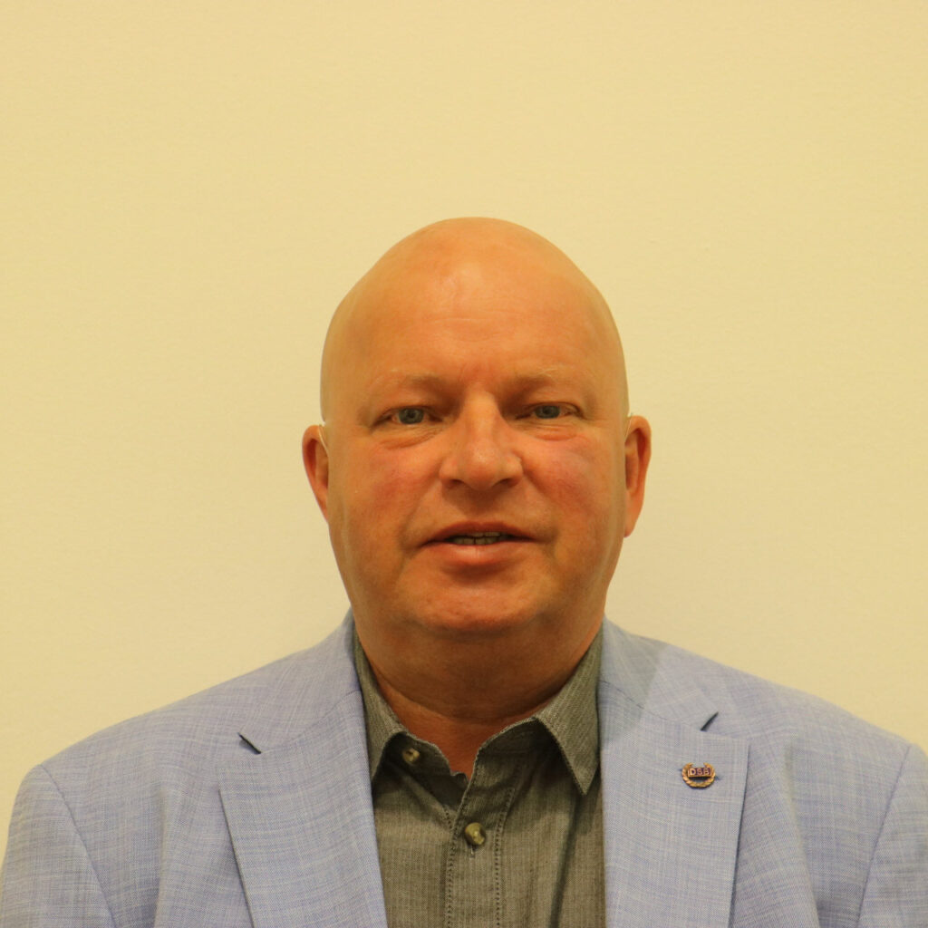 Profilbild von Jörg Henke, mit blauem Jaket und Glatze
