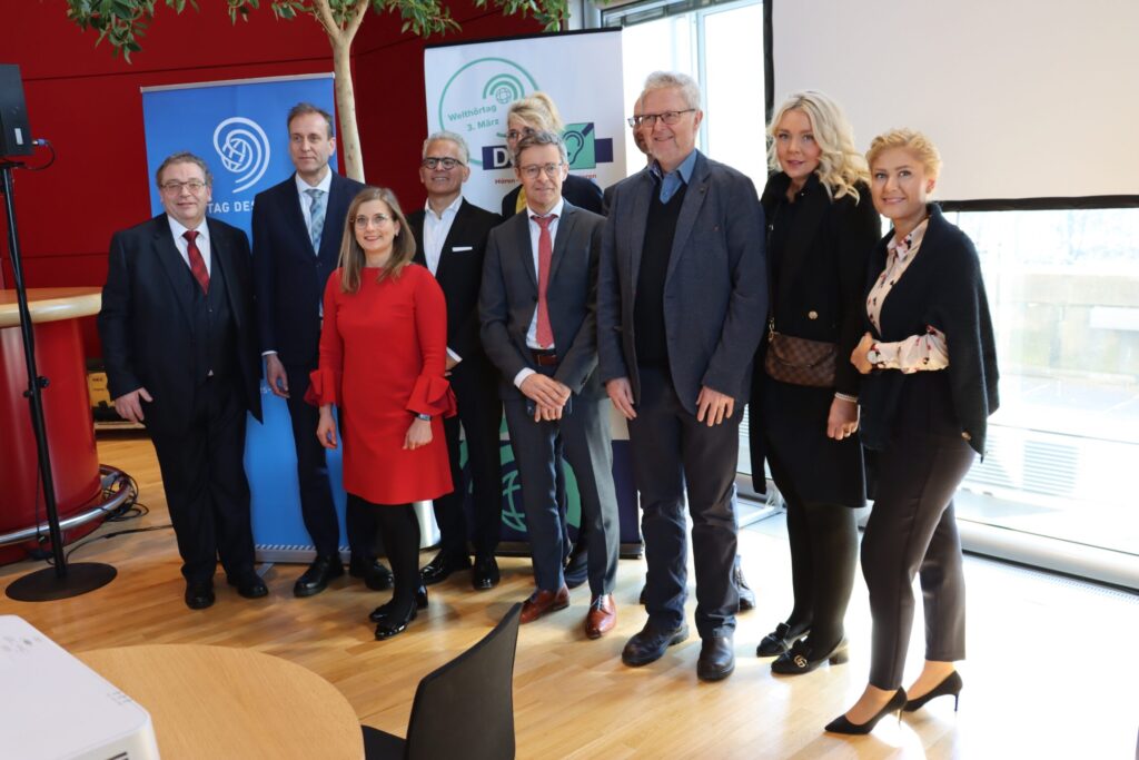 4 Frauen und 6 Männer stehen für ein Gruppenbild dichtbeieinander und lächeln
